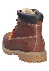 Bottine en cuir marron avec un col rembourré, une accent orange, un laçage durable et une semelle en caoutchouc crantée. Présente un logo et des coutures contrastées.