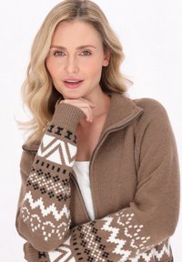 Bruine zip-up cardigan met geribbelde textuur en patroon mouwen in wit en zwart, met geometrische ontwerpen en een comfortabele pasvorm.