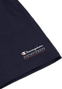 Pantaloni corti atletici in cotone blu navy con logo "Champion" bianco e testo "ATHLETICWEAR" in rosso, con una texture liscia e orlo dritto.