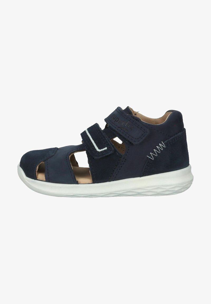 Marineblå børnesandal i ruskind, med udskæringer, justerbare velcro-stropper og en hvid gummisål med tekstureret detalje.
