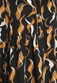 Tissu noir arborant un motif abstrait de formes tourbillonnantes orange et blanches, avec un devant boutonné et un détail de taille froncée.