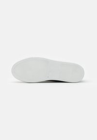 Semelle de chaussure en caoutchouc blanc avec un motif de grip texturé, bout légèrement arrondi et talon plat. Fini lisse sans accents ni logos visibles.