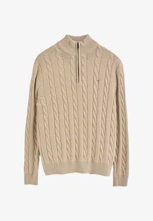 Suéter de punto beige con un alto cuello y detalle de cremallera. Presenta un patrón texturizado, puños y dobladillo acanalados. Apariencia de tela suave.