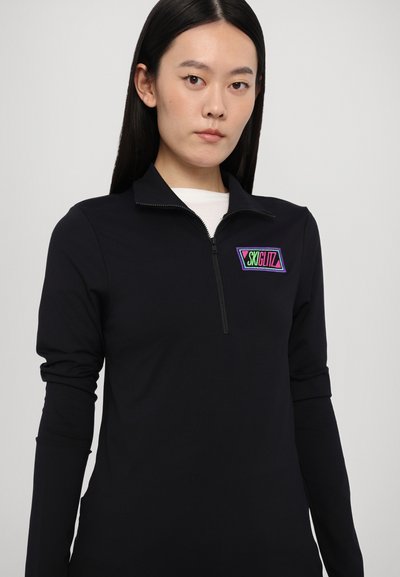 Black zip-up long-sleeve top made of smooth material, featuring a colorful "SKIGLITZ" logo on the chest. Minimalist design with a structured collar.