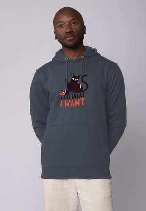 Donkergrijze hoodie van zachte stof met een afbeelding van een zwarte kat met witte ogen en rode accenten, de tekst luidt "IK DOE WAT IK WIL."
