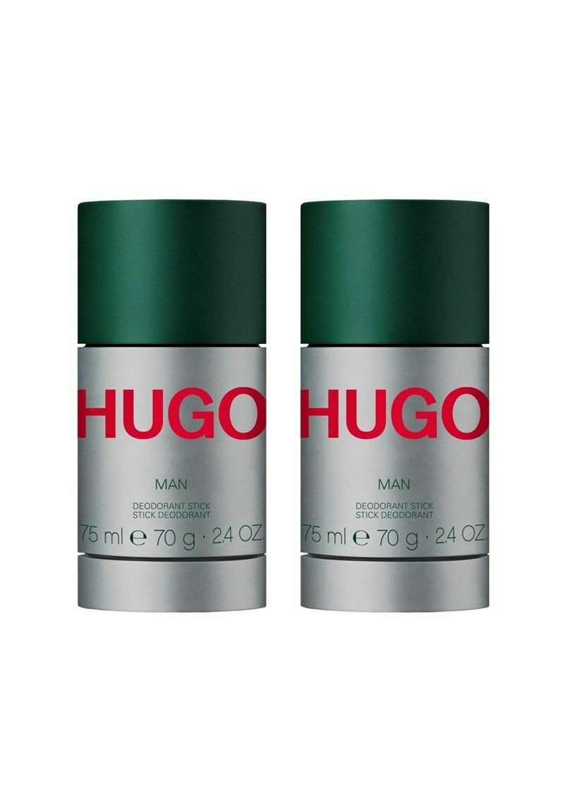 Två deodorantstift med gröna lock och silverfärgade baser. Etiketterna inkluderar röd text och detaljer: "HUGO MAN," "75 ml," "70 g," och "24 OZ."