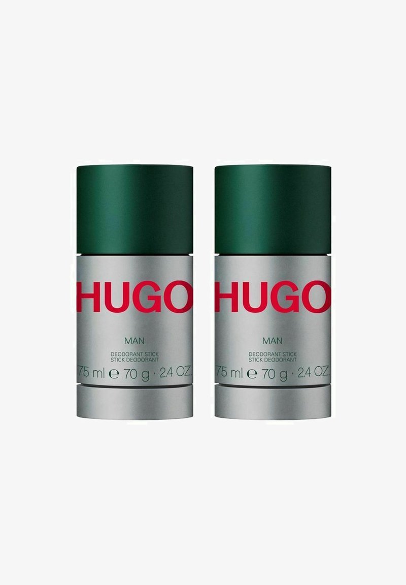 Kaksi deodoranttitikku, joissa on vihreät korkit ja hopeiset pohjat. Tägissä on punaisia tekstejä ja tietoja: "HUGO MAN," "75 ml," "70 g," ja "24 OZ."