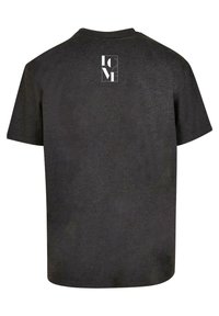 Svart kortermet T-skjorte laget av mykt stoff, med et kvadratisk logo i hvitt på den øvre ryggen. Klassisk rund hals-design.