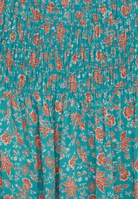 Tissu turquoise orné d'un motif floral en rouille et blanc. Texture froncée avec un détail smocké vertical sur toute la surface.