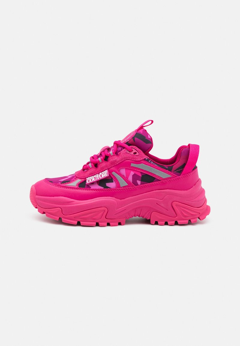 Lyserød chunky sneaker med mønstret overdel, reflekterende detaljer, tyk tekstureret sål og "Versace Jeans Couture" logo på siden.