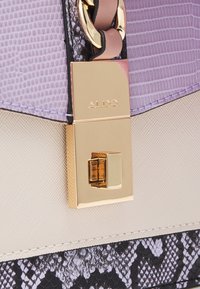 Fioletowo-czarna torebka w motyw węża z złotym okuciem, posiadająca teksturowaną powierzchnię, zapięcie na zatrzask oraz logo ALDO.