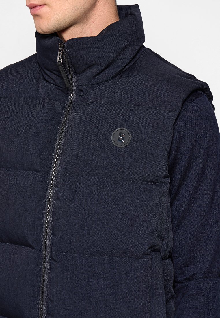 Navyblaue gepolsterte Weste mit hohem Kragen, ausgestattet mit einem Reißverschluss und einem runden Logodetail auf der Brust. Strukturierter Stoff mit glatter Oberfläche.