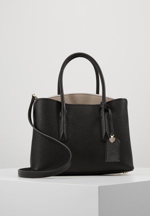 Sort tekstureret læderhåndtaske med to håndtag, aftagelig skulderrem og beige indre, udstillet på en hvid piedestal mod en grå baggrund.