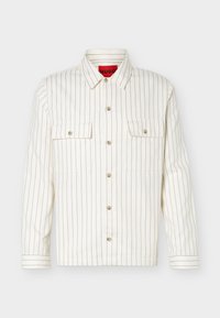 Λευκό πουκάμισο με μακριά μανίκια, λεπτές μαύρες κάθετες ρίγες, δύο μπροστινές τσέπες στο στήθος με κουμπιά και μυτερός γιακάς.