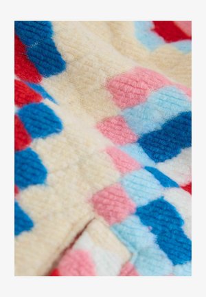 Farverig strikket stof med et ternet mønster bestående af blå, pink, røde og cremefarvede firkanter. Teksturen er blød og fnugget.
