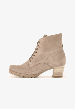 Bottines en suède beige avec un bout arrondi, un laçage à l'avant et un talon en bloc texturé. Présente une languette à l'arrière et une semelle en caoutchouc.