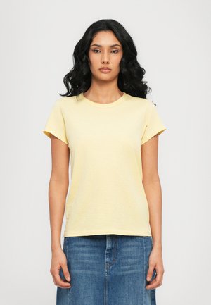 Yellow short-sleeve T-shirt with a round neckline and a relaxed fit, made from soft fabric. Paired with a blue denim skirt.