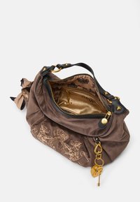 Bolsa de camurça castanha com um fecho em forma de charme dourado, detalhes em pele preta e um interior estampado. Possui um fecho zip e bordados decorativos.