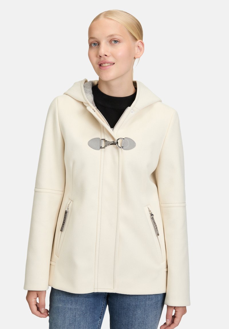 Cremefarvet frakke med hætte, lynlåslommer og knaplukning. Lavet af et glat, blødt materiale med subtile syninger.