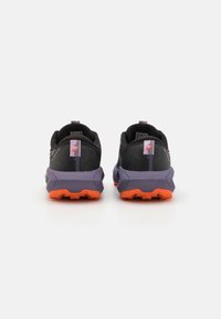 Trail running shoes with black textile upper, purple heel counter, and orange rubber outsole. Features textured patterns and reflective detailing.