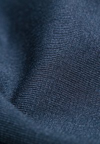 Dunkelblauster, strukturierter Stoff mit einem feinen gerippten Muster, das glatte, weiche Fasern und einen leichten Glanz zeigt. Flexible und drapierbare Qualität.