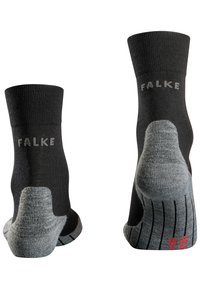 Calcetines negros con acentos grises en el talón, diseño acanalado y logotipo "FALKE" en plata. Presentan un agarre texturizado adicional en la suela.