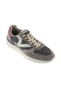 Sneaker con tomaia in suede e mesh grigia e beige, suola in gomma bianca, lacci crema e un'acca rossa con branding. 