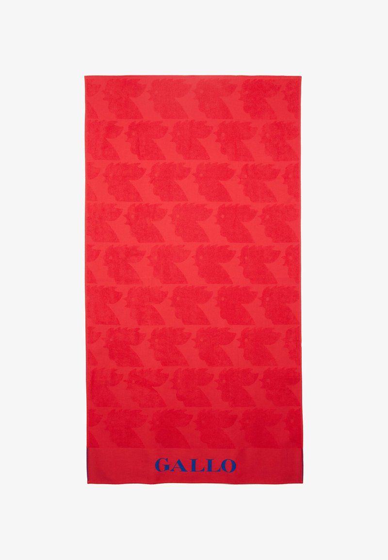 Asciugamano rosso con motivi astratti di uccelli ripetuti in un design tonale. In basso presenta un accento di testo blu "GALLO". Tessuto morbido e testurizzato.