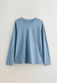 Long-sleeve shirt in light blue cotton with a round neck and a small logo on the chest. Smooth texture, relaxed fit, simple design.