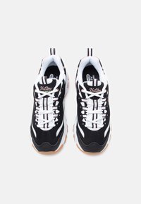 Černobílé sportovní boty s texturovaným semišovým svrškem, kulatou špičkou, gumovou podrážkou a vícebarevnými tkaničkami. Na jazyku je viditelné logo značky.