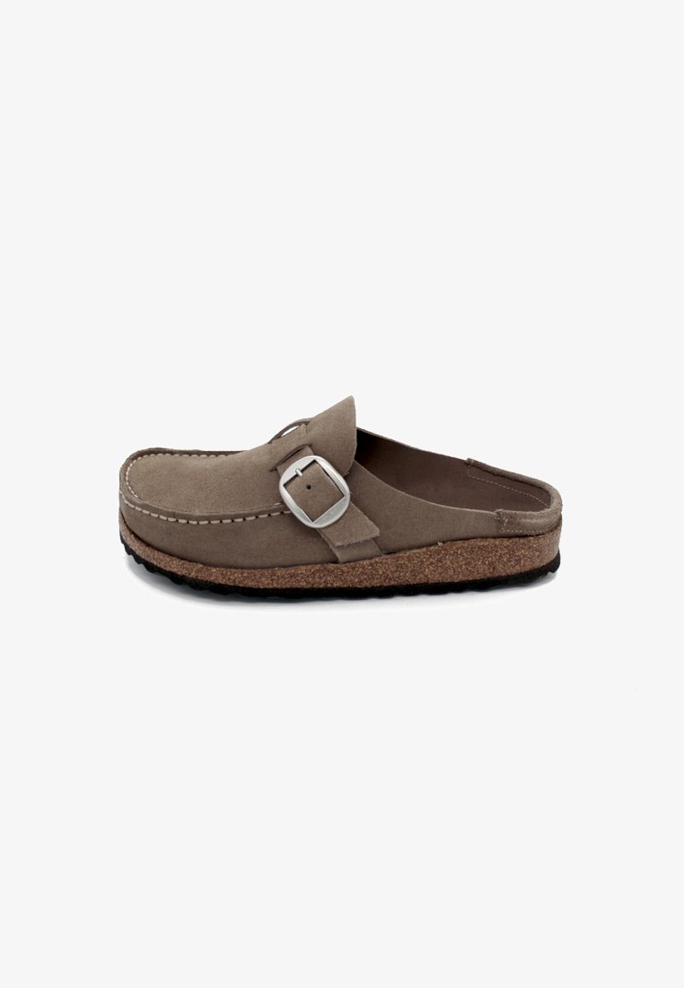 Brauner Wildleder-Schlüpfschuh mit runder Spitze, silberner Schnallenakzent und Korksohle. Mit gestickten Details entlang des oberen Randes. Rutschfeste schwarze Laufsohle.