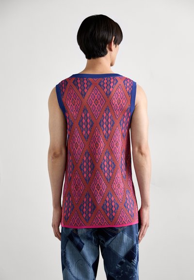 Top senza maniche caratterizzato da un motivo geometrico in rosso, rosa e blu, con scollatura a costine e tessuto testurizzato.