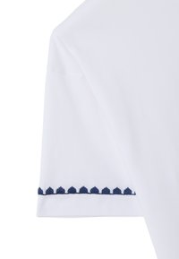 Witte katoenen t-shirt met mouwen, versierd met marineblauwe scalloped borduursels langs de zoom. Soepele textuur met een klassiek ontwerp.