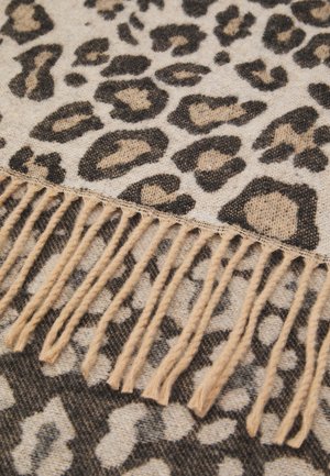 Leopardenmusterstoff in Beige und Schwarz, mit einer weichen Textur und fransigen Kanten. Das Design umfasst kräftige, unregelmäßige Flecken.