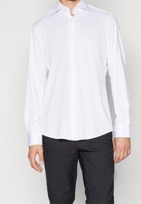 Wit overhemd met lange mouwen, gemaakt van een gladde stof, met een knoopsluiting aan de voorkant, een klassieke kraag en contrasterende blauwe accenten op de manchetten.
