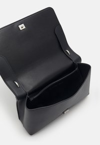 Czarna skórzana torba o gładkiej powierzchni, z otwartą klapą i srebrnymi akcentami metalowymi. Posiada przestronną wnętrze.