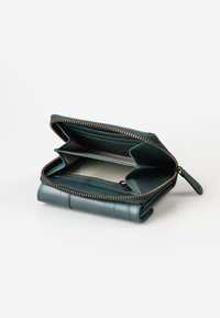 Portafoglio in pelle di colore teal, con chiusura con zip, diversi scomparti per carte e un interno decorato con una tasca con zip sicura.