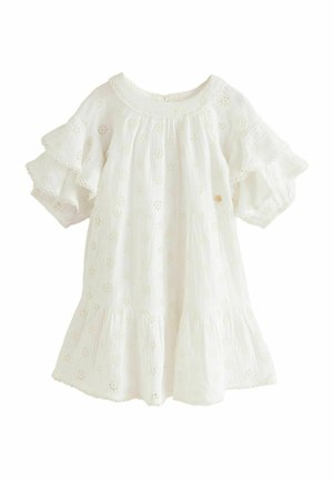 Vestido de algodón blanco bordado con mangas en volantes de capas, recortes florales y un escote redondeado. Se cierra con un botón en la parte posterior.