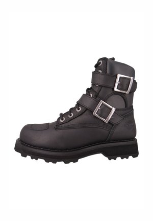 Bota de motocicleta de cuero negro con hebillas metálicas, diseño con cordones, punta reforzada, suela resistente y logo grabado en el costado.