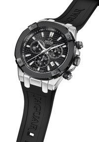 Schwarze Chronographuhr mit strukturierter schwarzer Zifferblatt, silbernen Akzenten und einem Gummiband. Verfügt über drei Unterzifferblätter und das Jaguar-Logo.