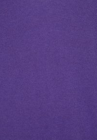 Pletenina v jednolitém, výrazném fialovém odstínu, s hladkou texturou a rovnoměrným úpletem, bez viditelných vzorů či ozdob.