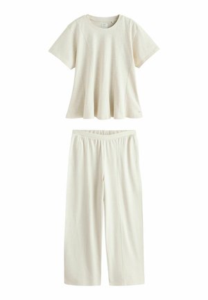 Kremowa prążkowana dzianinowa bluzka z krótkim rękawem i rozkloszowanym dołem, zestawiona z pasującymi szerokimi spodniami z elastyczną talią.