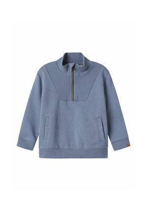 Blå sweatshirt med hög krage, dragkedja vid halsen, ribbat mönster på axlarna och sidofickor. Har en enhetlig färg och avslappnad passform.