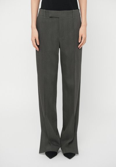 Pantaloni grigi a gamba larga in tessuto leggero con una texture liscia, dotati di tasche frontali e una vita piatta. Design sartoriale con piega.