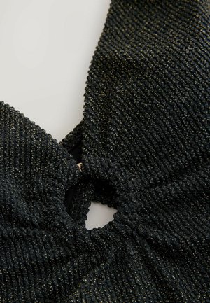 Crni teksturirani materijal s uskim, skupljenim središtem i zlatnim mrljama. Ima kružni otvor na sredini i dizajn s halter izrezom.