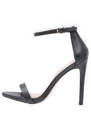 Zwarte hoge sandaal met een enkelbandje, textuurmateriaal, open teenontwerp en een slanke stilettohak. Inleger in neutrale kleur.