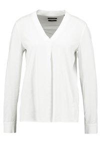 Chemise blanche à manches longues avec col en V, texture lisse et coupe décontractée. Design simple sans motifs ni accents visibles.