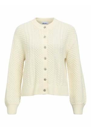 Kremowy kardigan z grubym splotem, z długimi rękawami, prążkowanym dołem oraz sześcioma ozdobnymi guzikami z przodu. Całość zdobiona teksturowanym wzorem.