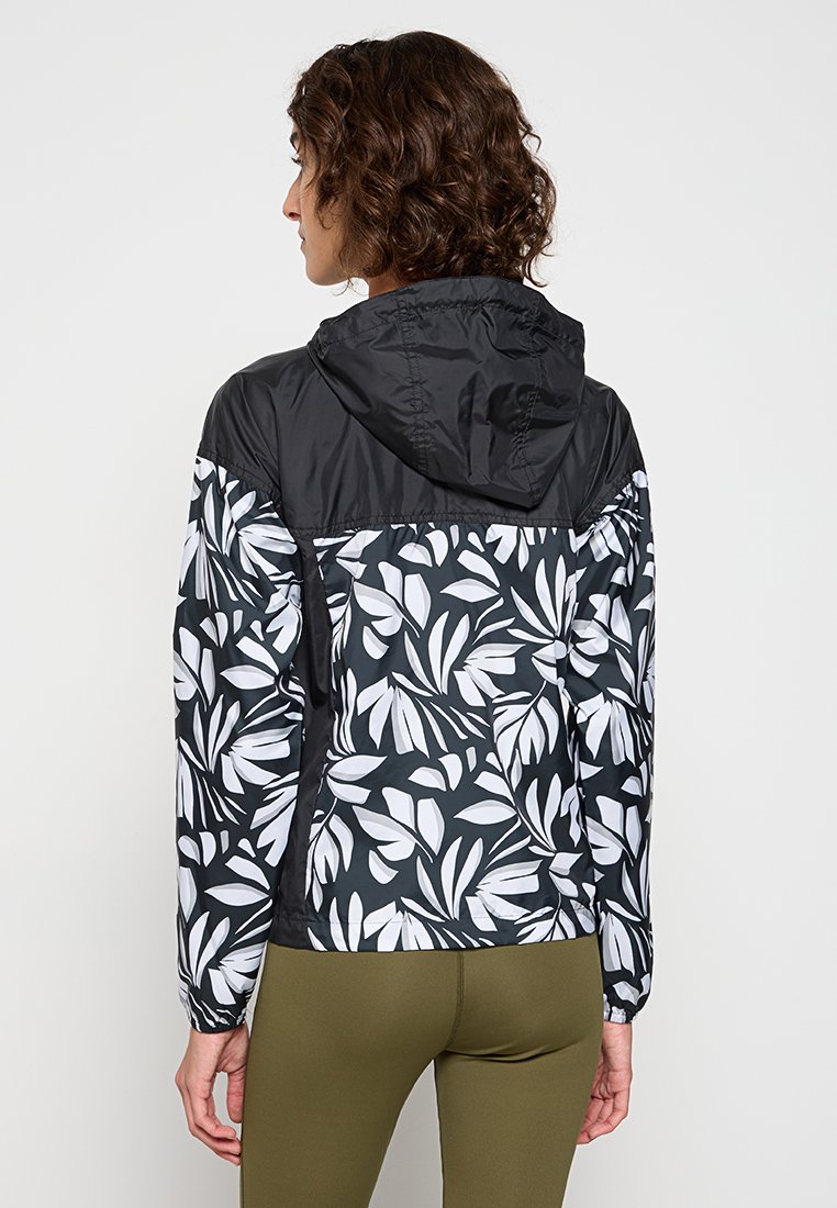 Chaqueta con capucha de patrón en blanco y negro, con un diseño de hojas, material ligero y puños elásticos. Adecuada para uso casual.