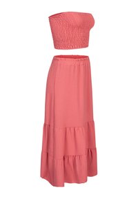 Ensemble deux pièces rose corail avec un crop top froncé sans bretelles et une longue jupe à volants avec une taille élastique.